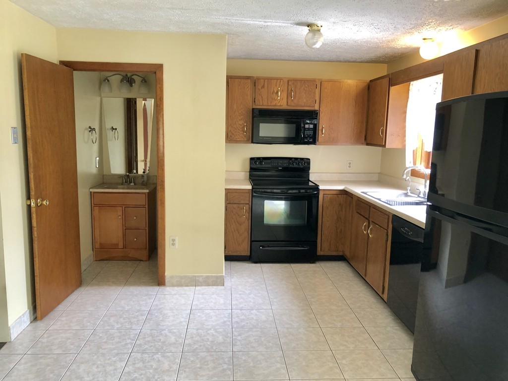 11 R Gamache Road, Unit 11R Derry, NH 03038 - Photo 8 of 20 a kitchen with stainless steel appliances granite countertop a refrigerator and a stove