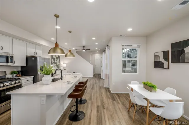 a view of a dining room with furniture a rug and wooden floor