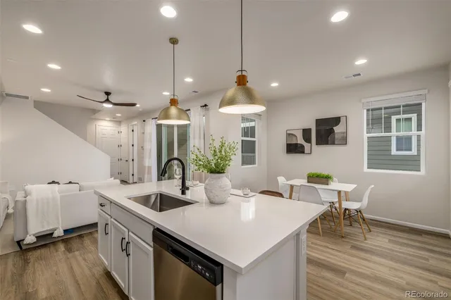 a kitchen with granite countertop a sink a counter space appliances and cabinets