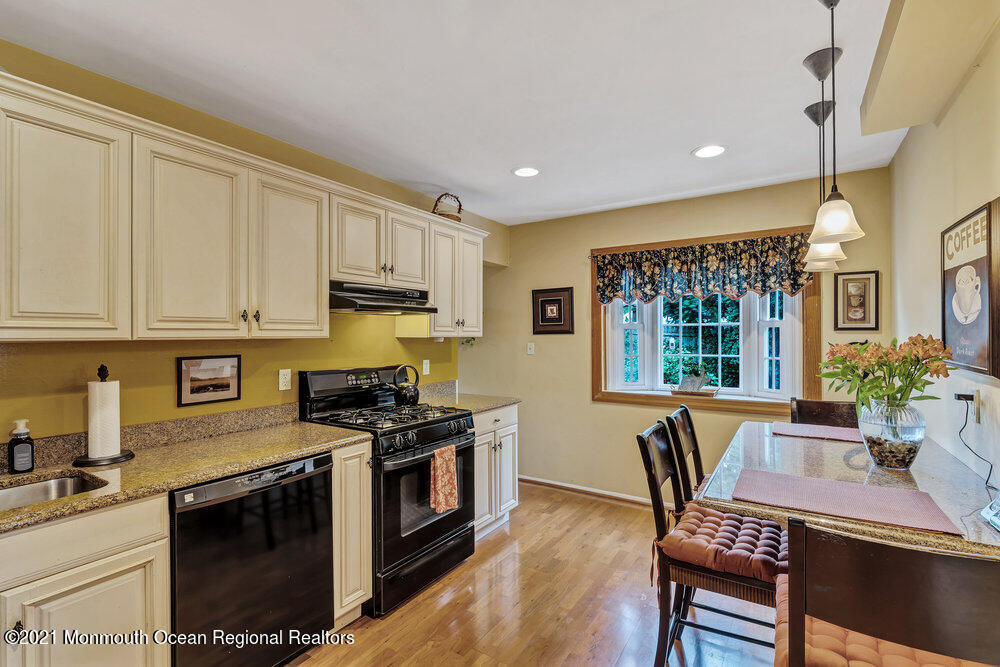 24 Limerick Place Hazlet, NJ 07730 - Photo 13 of 36 a kitchen with stainless steel appliances granite countertop a stove a sink dishwasher a microwave oven with a dining table and chairs