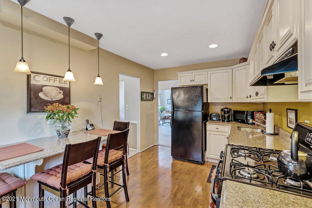 24 Limerick Place Hazlet, NJ 07730 - Photo 15 of 36 a kitchen with stainless steel appliances granite countertop a refrigerator a stove a sink dishwasher and a dining table with wooden floor