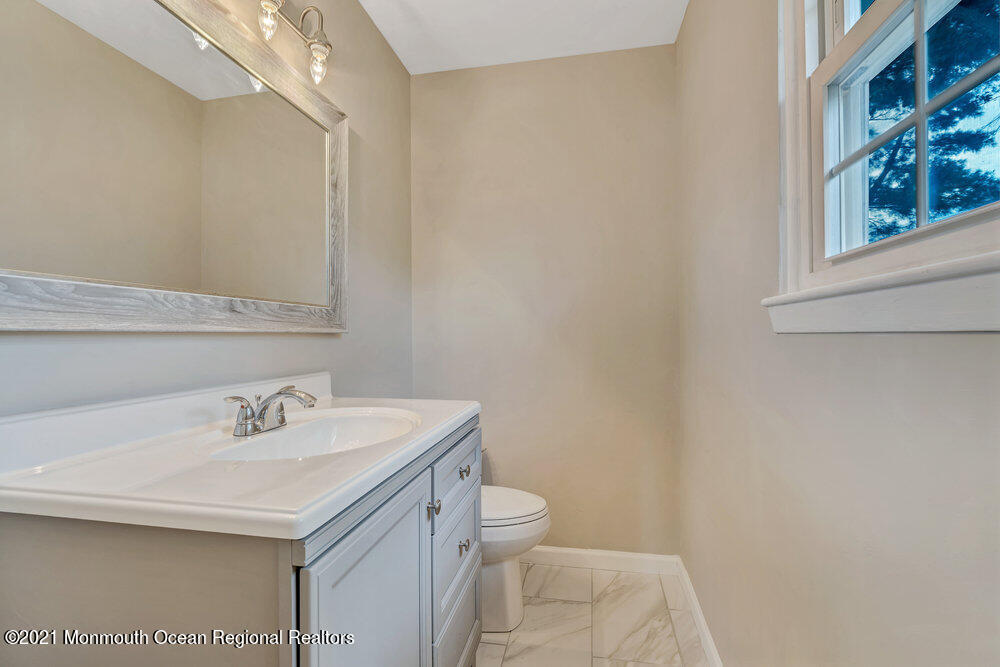 24 Limerick Place Hazlet, NJ 07730 - Photo 31 of 36 a bathroom with a sink a toilet and a mirror