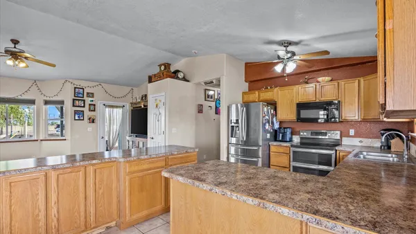 a kitchen with stainless steel appliances granite countertop a sink a stove and a wooden cabinets