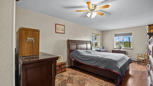 a bedroom with a bed and dresser with mirror