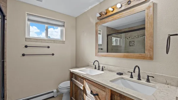 a bathroom with a granite countertop toilet a sink and a mirror