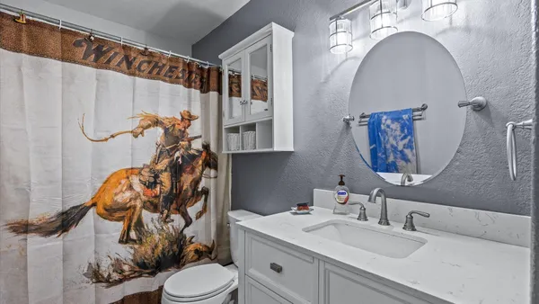 a bathroom with a sink a toilet and a mirror