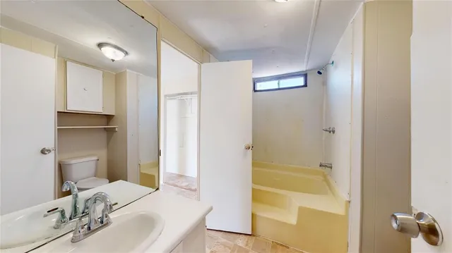 a bathroom with a tub sink and mirror