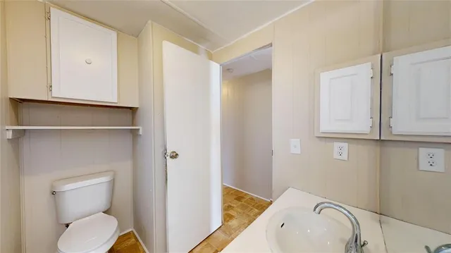 a bathroom with a toilet a sink and mirror