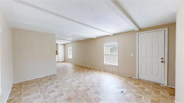 a view of an empty room with window and closet area