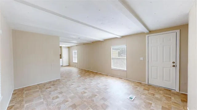a view of an empty room with window and closet area