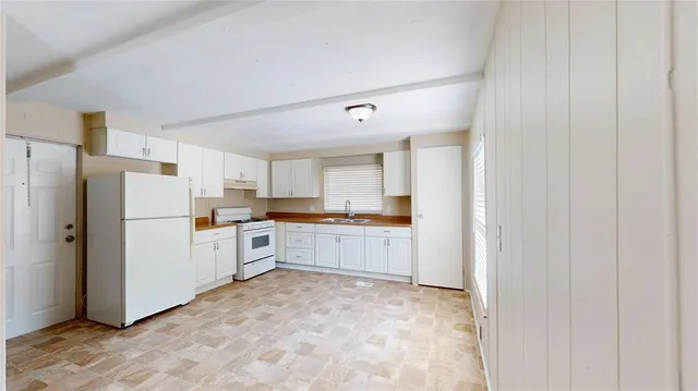a kitchen with white cabinets and white appliances