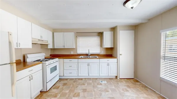 a kitchen with granite countertop a stove sink and cabinets