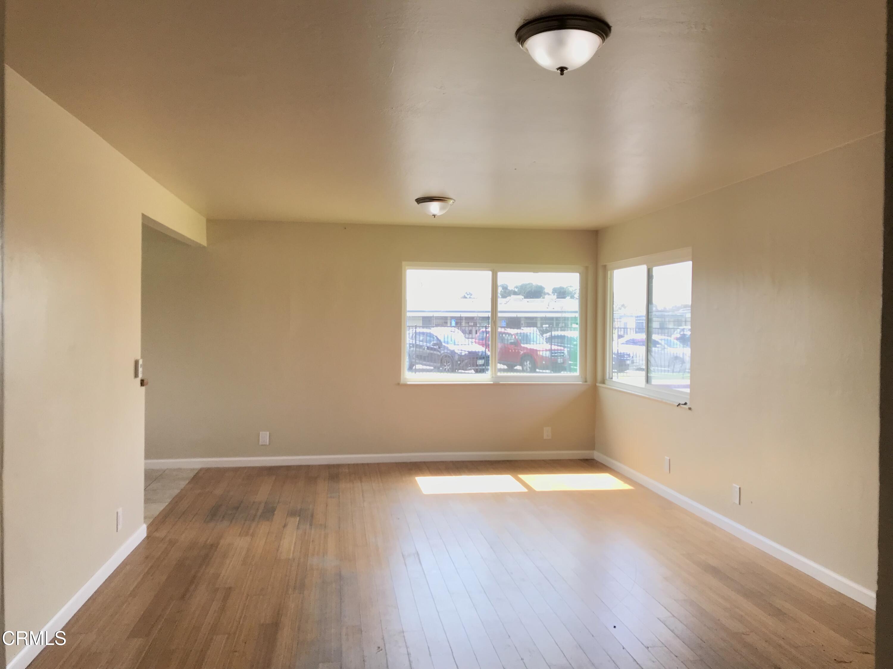 3148 Napa Street Oxnard, CA 93033 - Photo 4 of 15 an empty room with wooden floor and windows