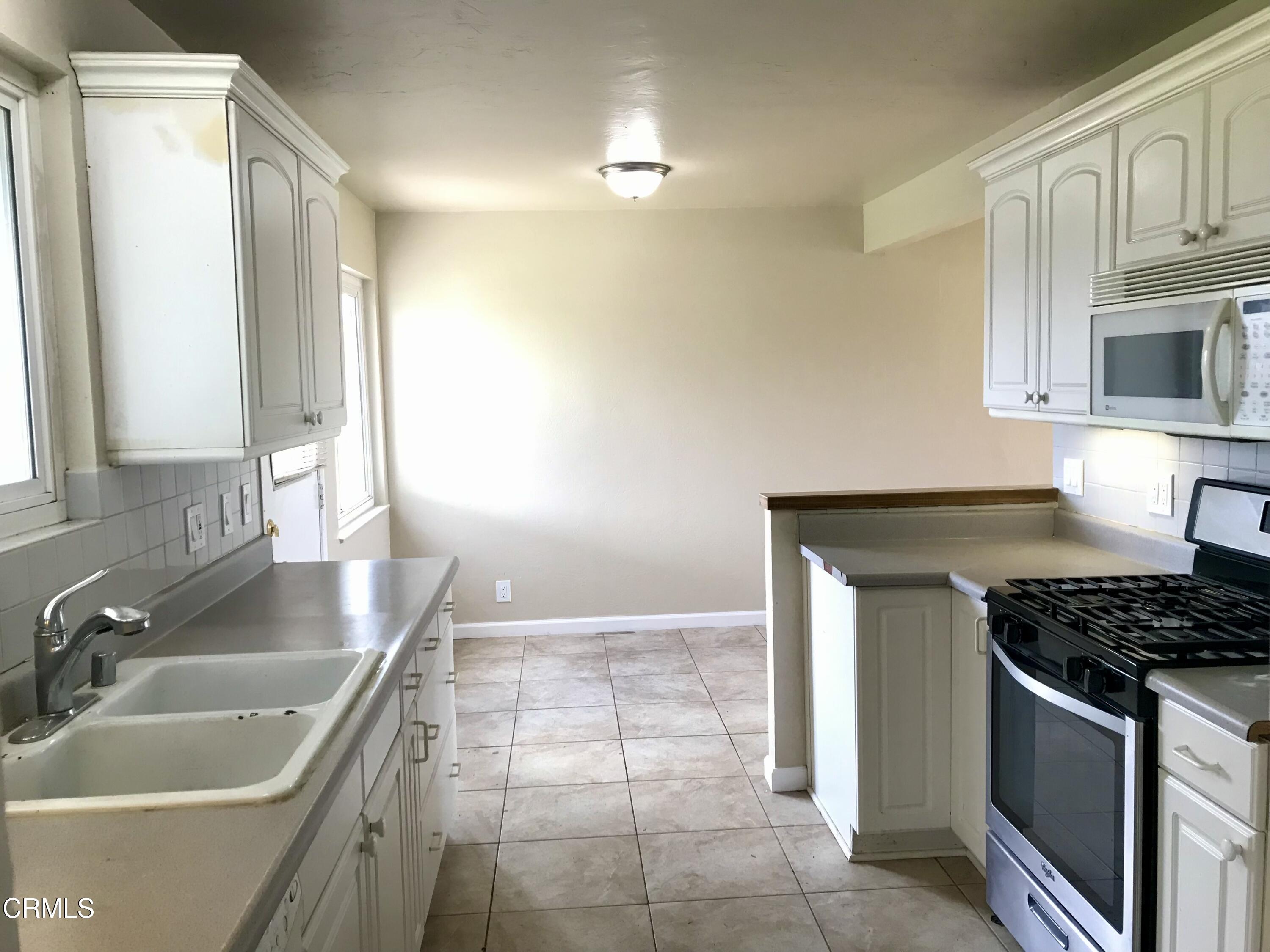 3148 Napa Street Oxnard, CA 93033 - Photo 5 of 15 a kitchen with granite countertop a sink stove and cabinets