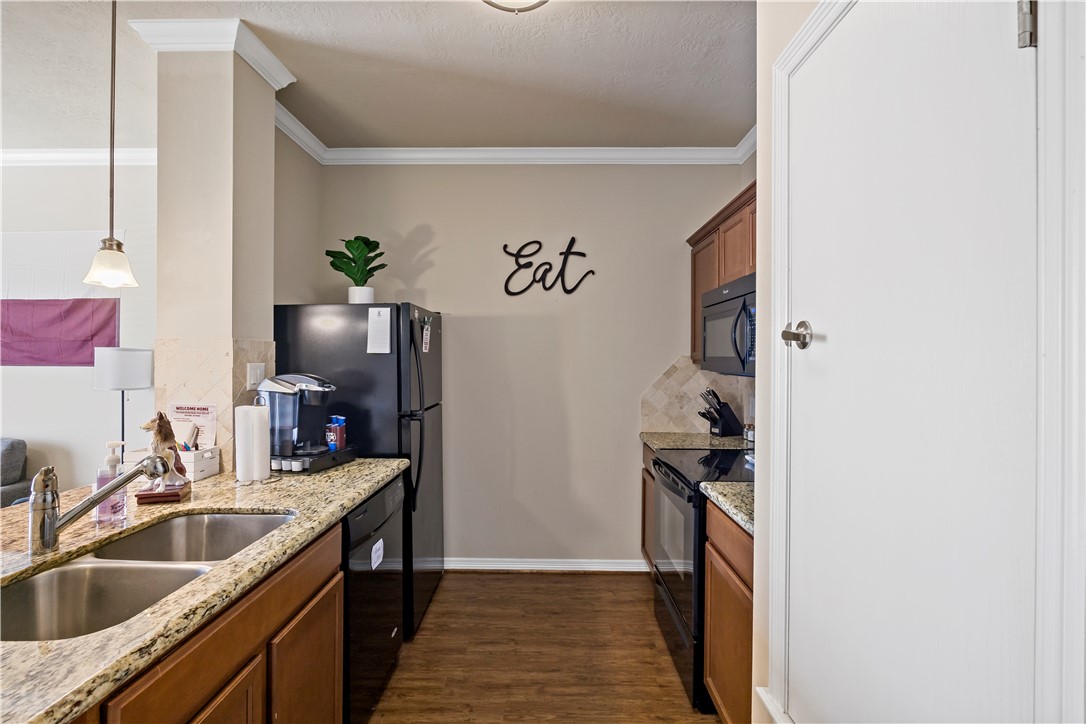 1198 Jones-Butler Road, Unit 2207 College Station, TX 77840 - Photo 6 of 14 a kitchen with granite countertop a sink and a stove top oven