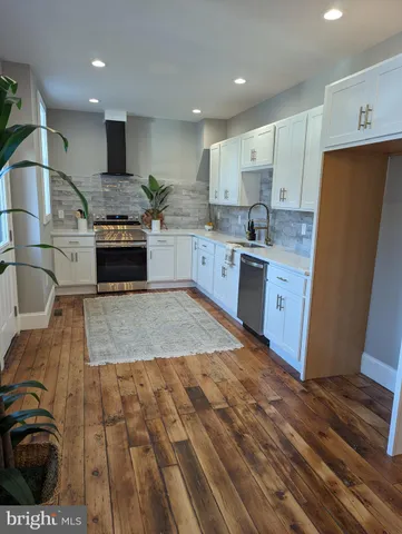 a kitchen with stainless steel appliances granite countertop a sink a stove a refrigerator and cabinets