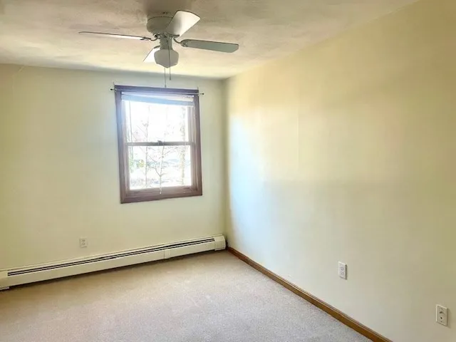 an empty room with a window and a ceiling fan