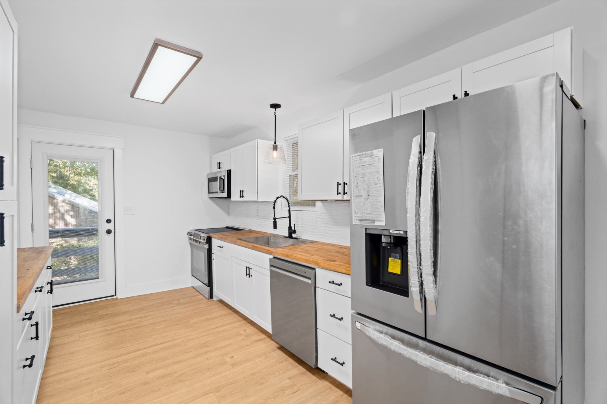 a kitchen with stainless steel appliances a refrigerator sink and cabinets