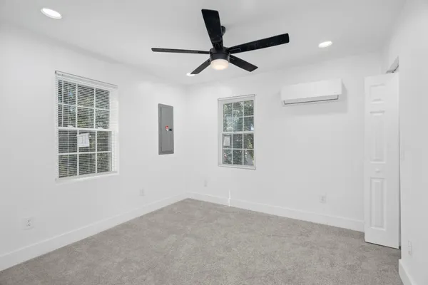 a view of a livingroom with a ceiling fan & windows