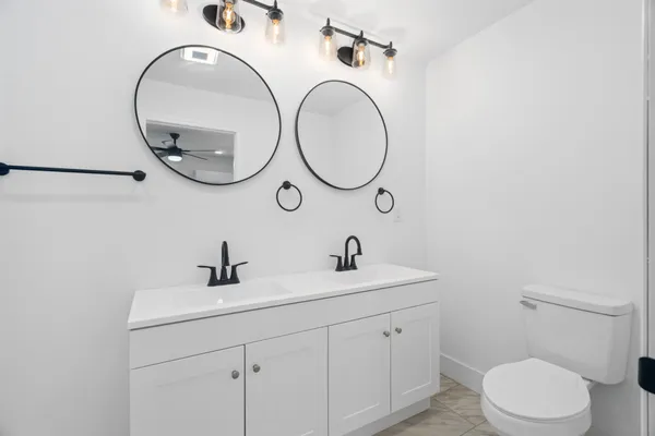 a bathroom with a toilet a sink and a mirror