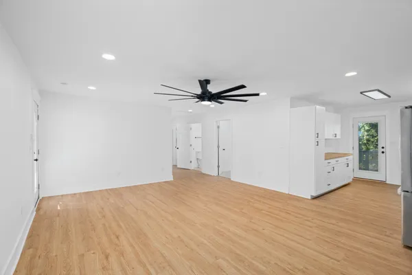 a view of a livingroom with a ceiling fan & entryway