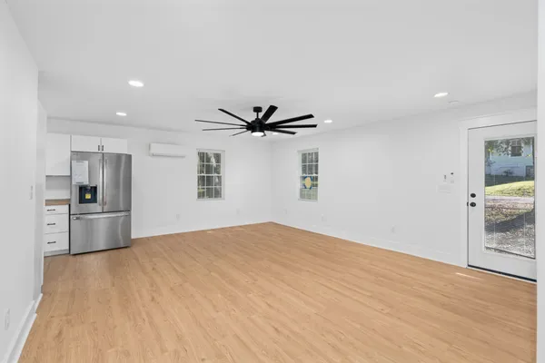 a view of empty room with wooden floor and window