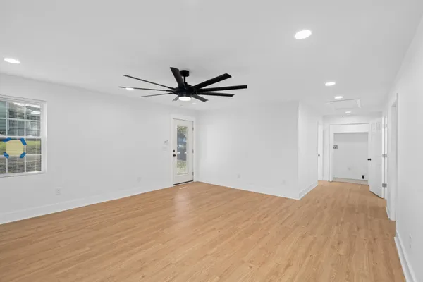 a view of a big room with wooden floor closet and windows
