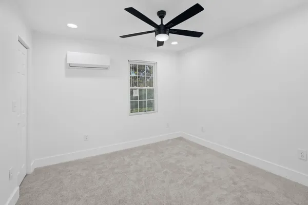 an empty room with a window and a fan