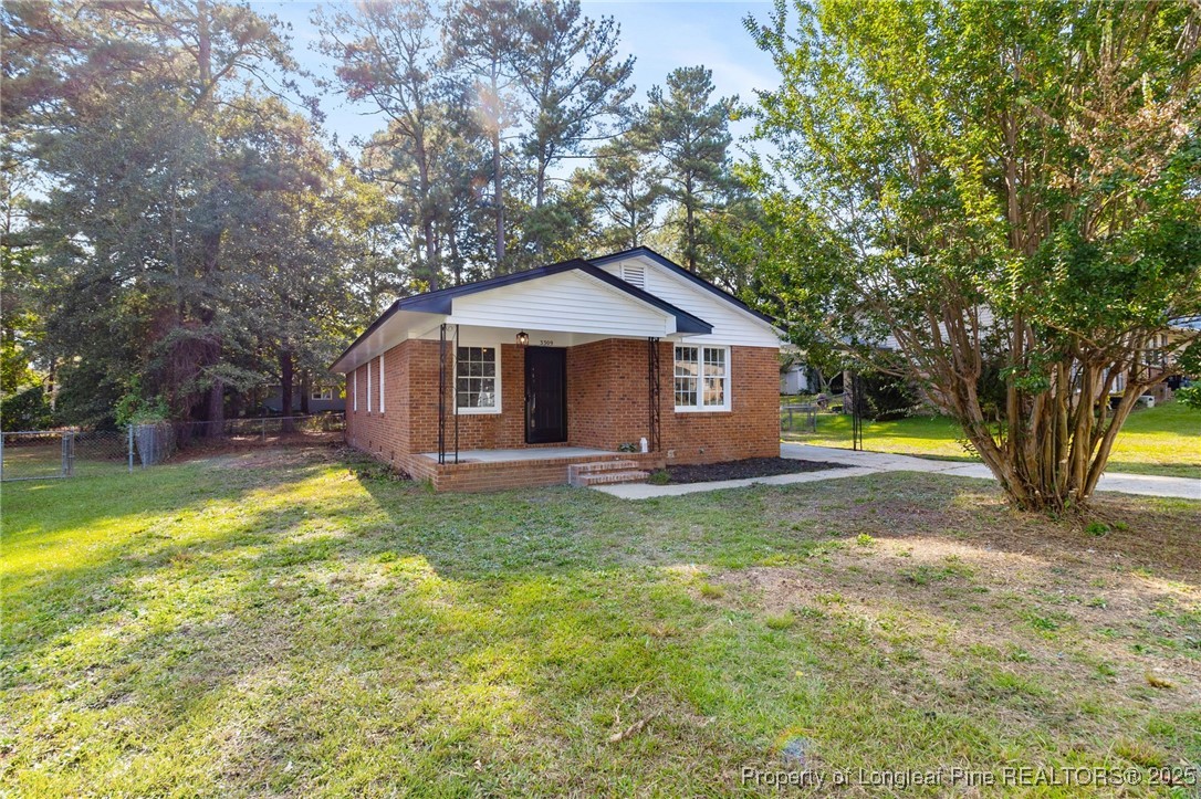 a view of a house with backyard and trees