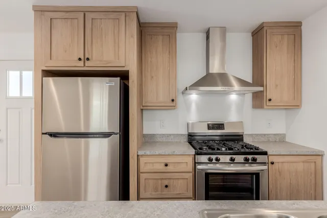a kitchen with stainless steel appliances granite countertop a stove a refrigerator and a cabinets