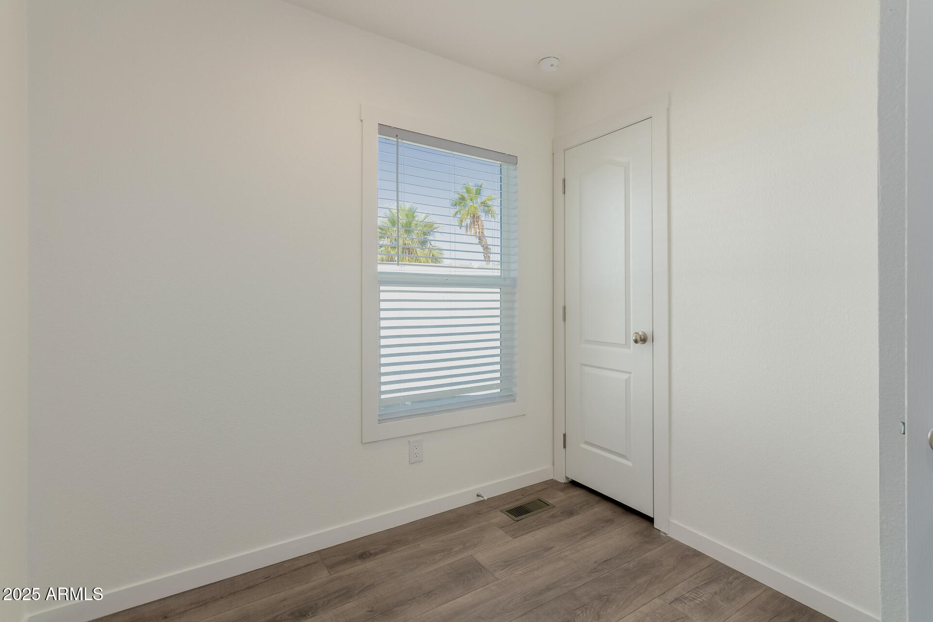 5201 West Camelback Road, Unit A257 Phoenix, AZ 85031 - Photo 8 of 13 a view of an empty room with wooden floor and a window