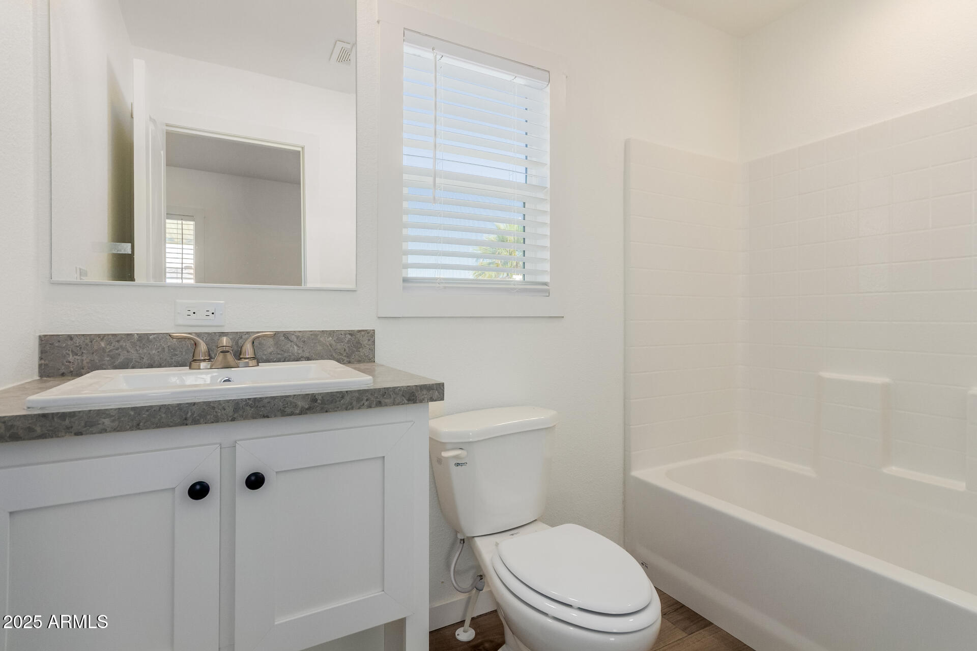 5201 West Camelback Road, Unit A257 Phoenix, AZ 85031 - Photo 10 of 13 a bathroom with a granite countertop toilet a sink and a bathtub