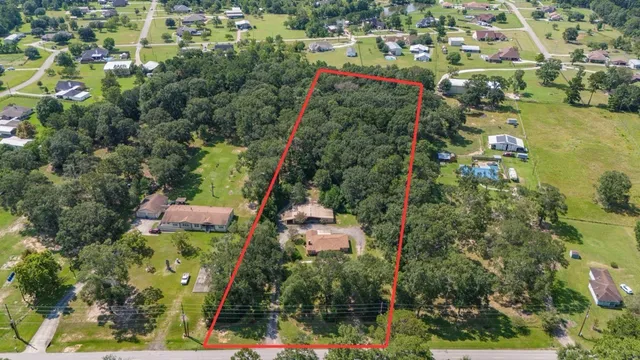 an aerial view of residential houses with outdoor space and trees