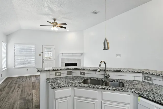 a kitchen with granite countertop a sink and a stove