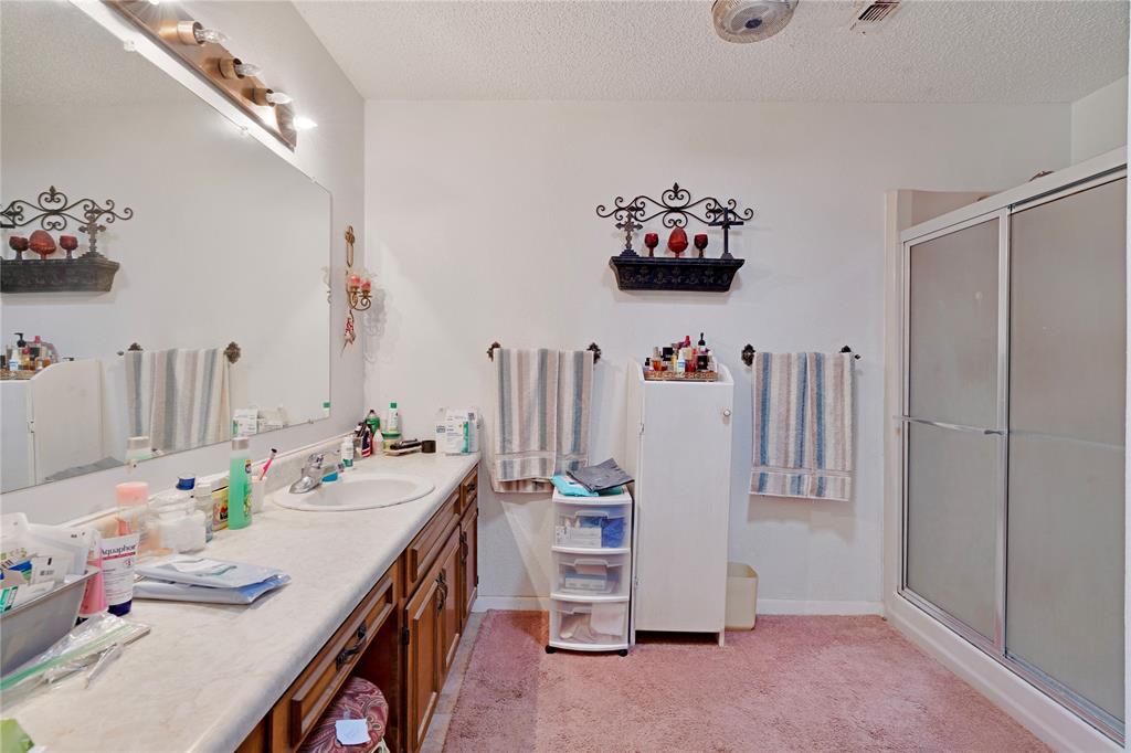1355 County Road 33100 Sumner, TX 75486 - Photo 32 of 34 Bathroom with an enclosed shower, vanity, a textured ceiling, and baseboards