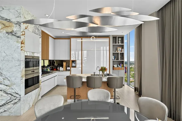 a kitchen with stainless steel appliances kitchen island granite countertop a sink and chairs