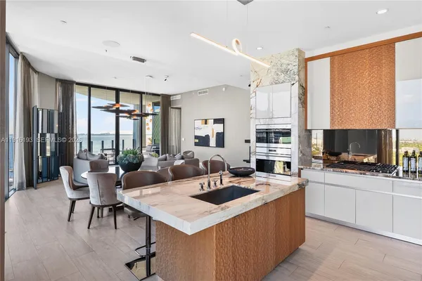 a view of a kitchen with kitchen island a sink table and chairs