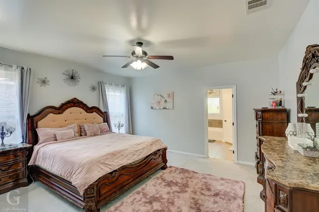 a bedroom with a bed and a mirror on dresser