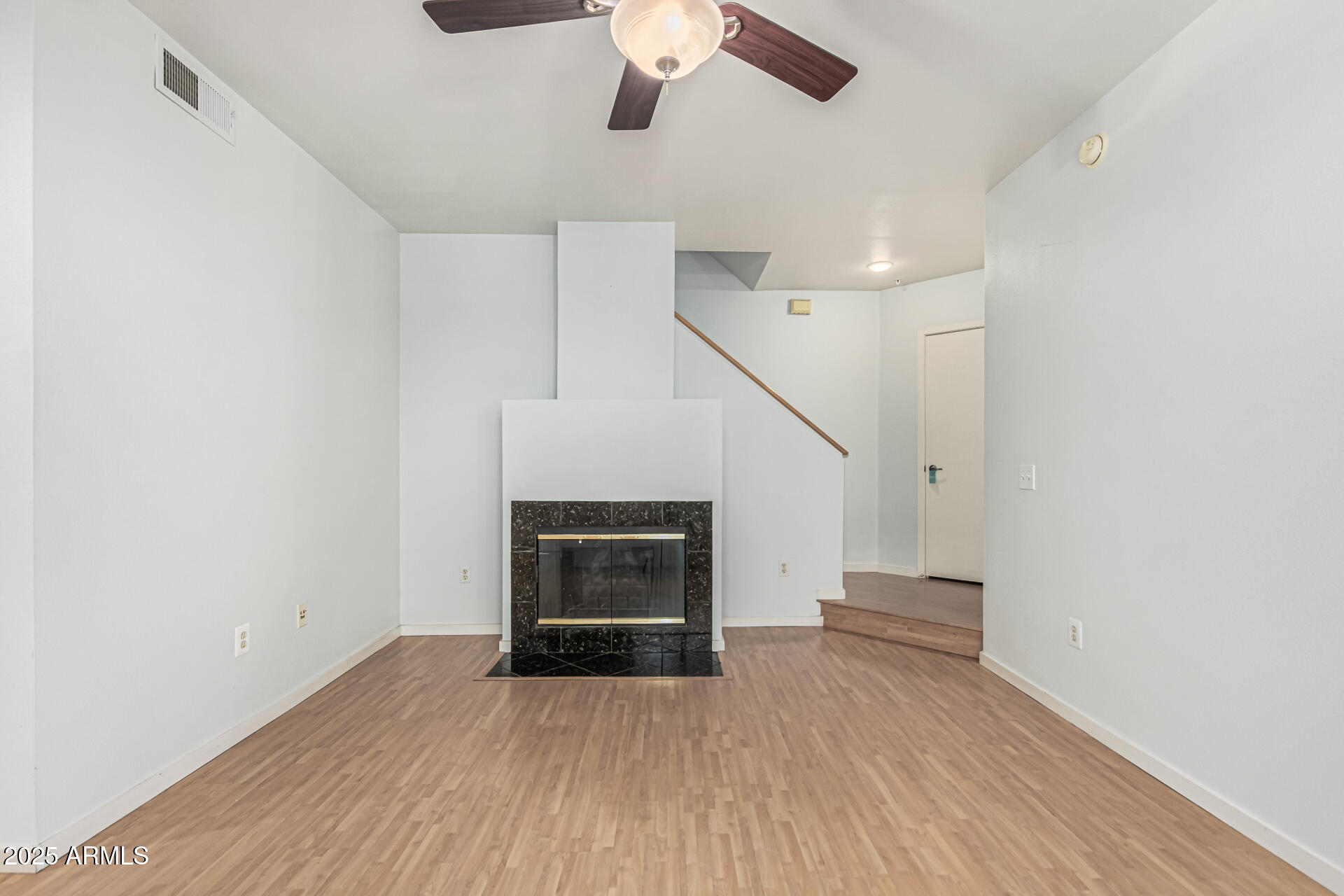 3633 North 3rd Avenue, Unit 2083 Phoenix, AZ 85013 - Photo 7 of 54 an empty room with wooden floor fireplace and chandelier