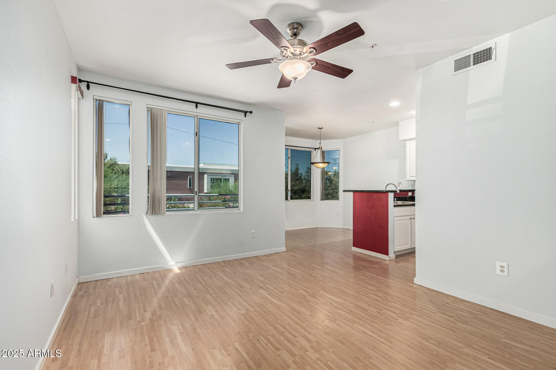 3633 North 3rd Avenue, Unit 2083 Phoenix, AZ 85013 - Photo 8 of 54 a view of an empty room with a window and wooden floor