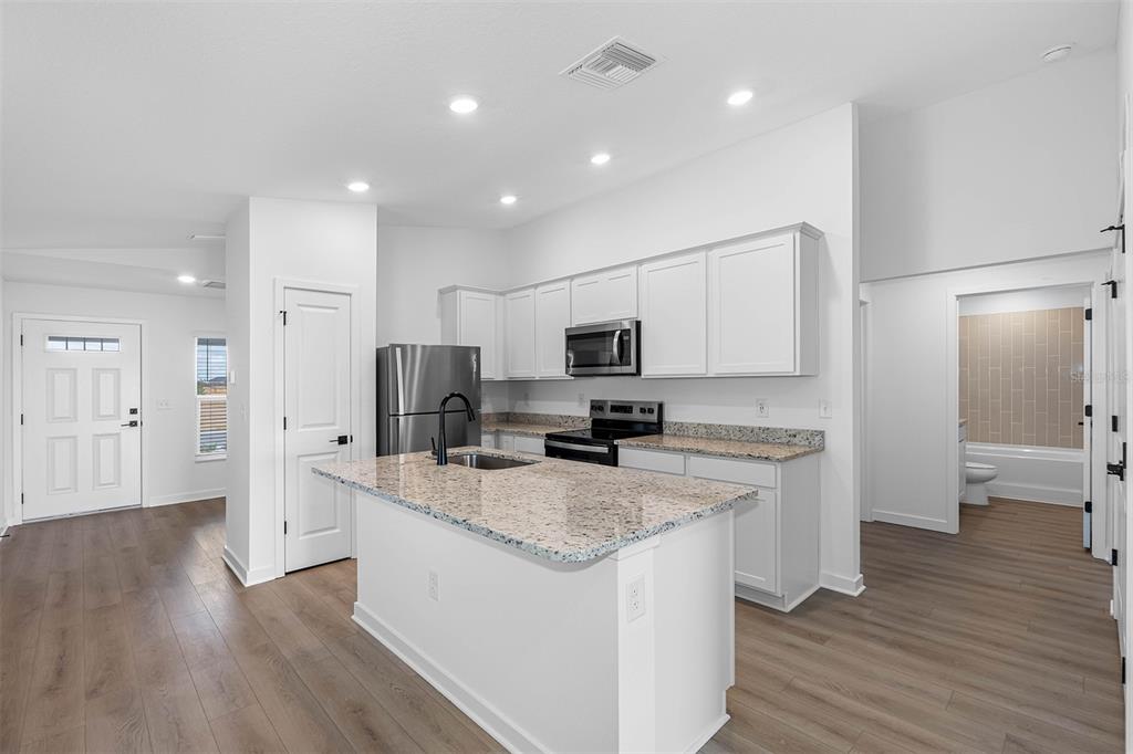 Undisclosed Address Lakeland, FL 33809 - Photo 2 of 7 a large kitchen with stainless steel appliances granite countertop a lot of counter space and wooden floors