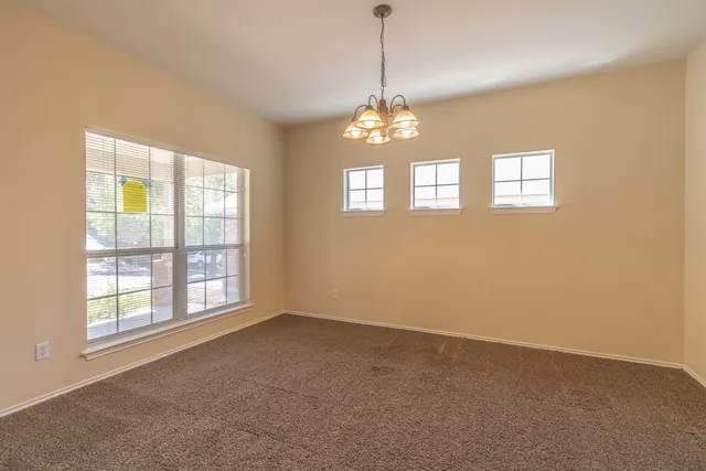 a view of a livingroom with a chandelier furniture and windows