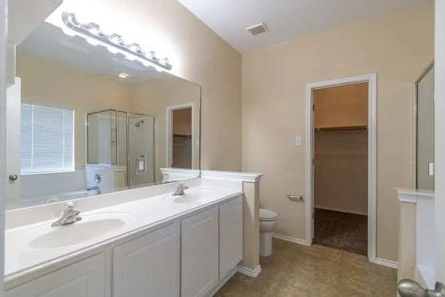 a spacious bathroom with a double vanity sink mirror and toilet
