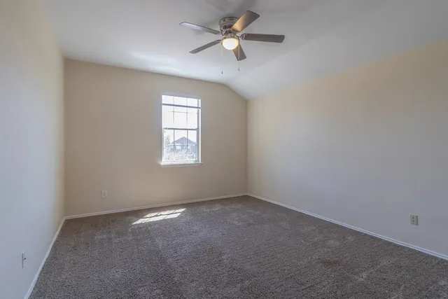 an empty room with a window and a fan