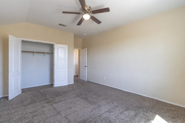 an empty room with closet and windows