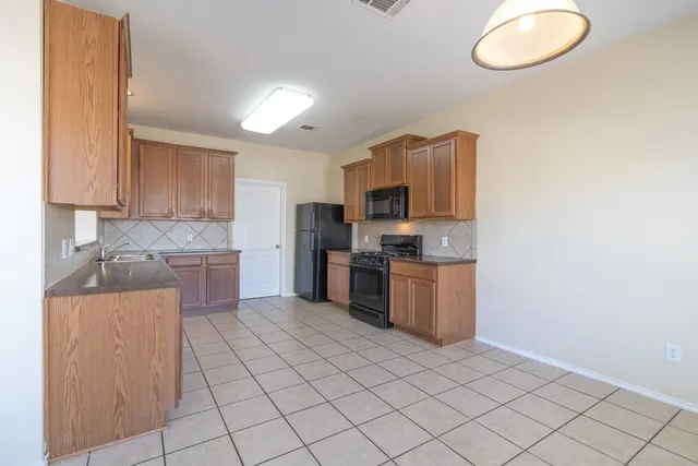 a kitchen with a sink a stove top oven and cabinetry