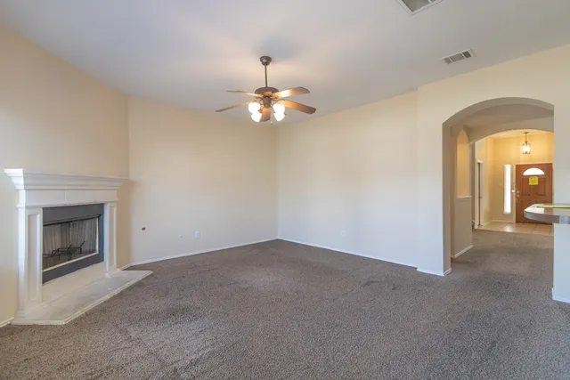a view of a livingroom with a chandelier fan and a fireplace