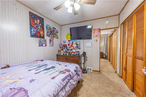 a bedroom with a bed window and flat screen tv