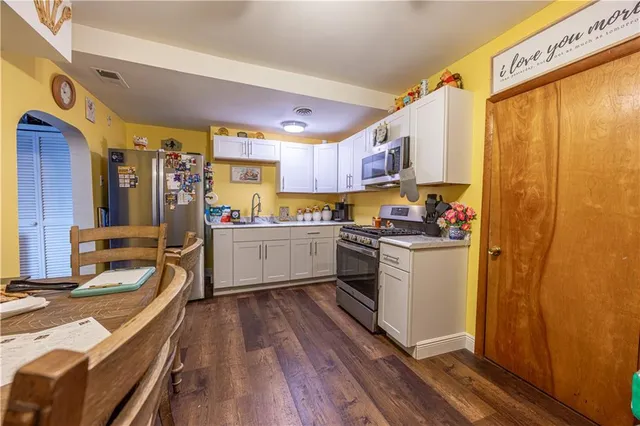 a kitchen with a refrigerator a sink and wooden cabinets