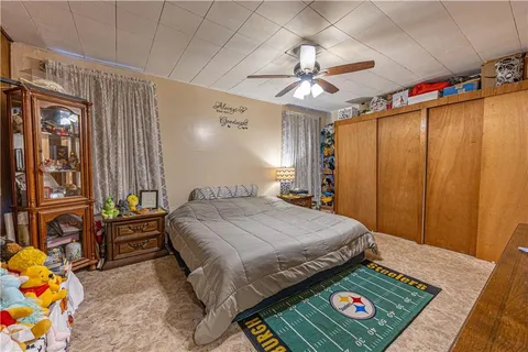 a bedroom with a bed a table and potted plants on the dresser